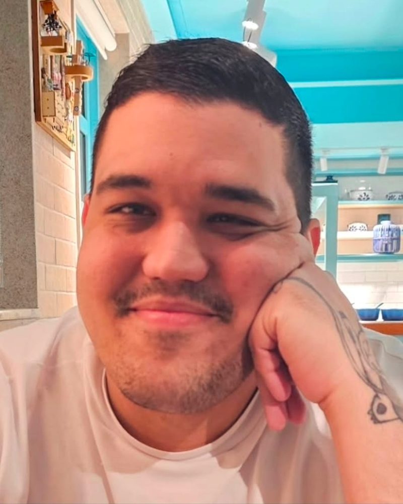 David sorrindo, com a mão apoiada no rosto